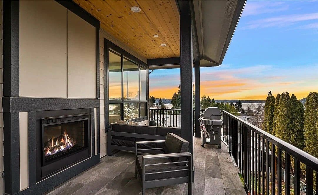 Covered outdoor living patio with fireplace at dusk
