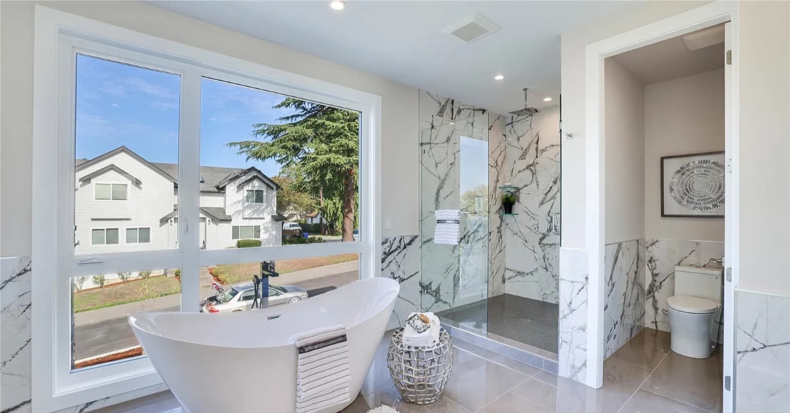 Freestanding tub beside a picture window